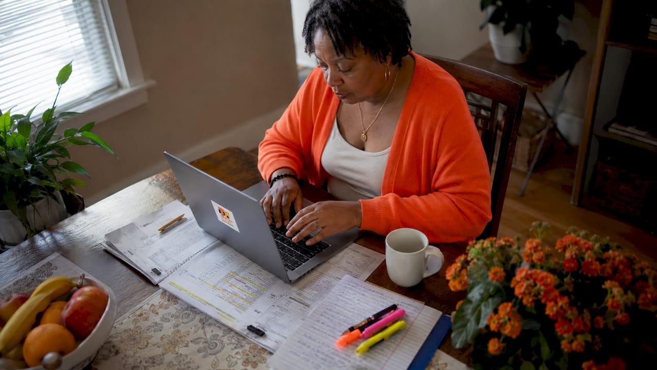 Claims adjuster typing communication records on laptop