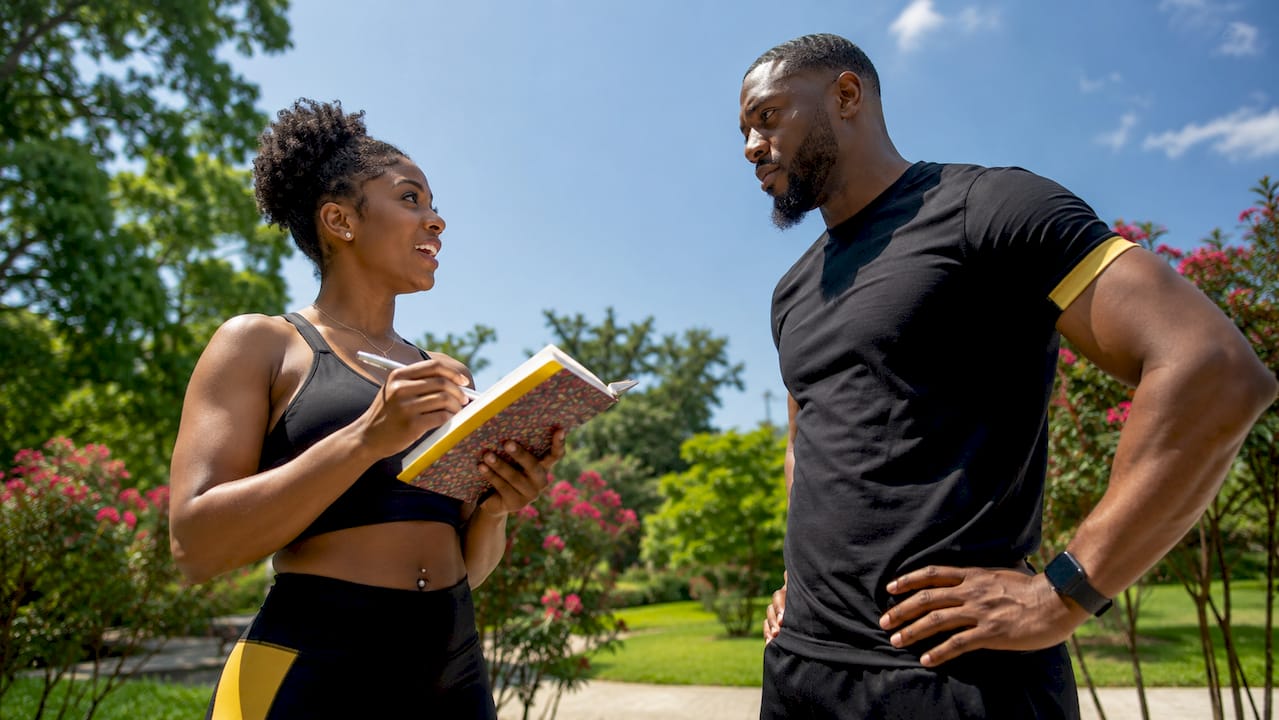Client discussing fitness goals with personal trainer