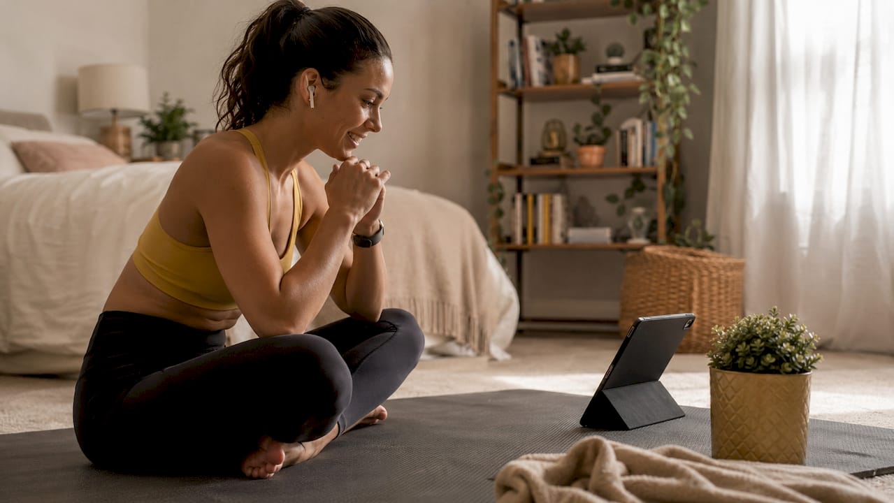 Woman doing online fitness coaching at home
