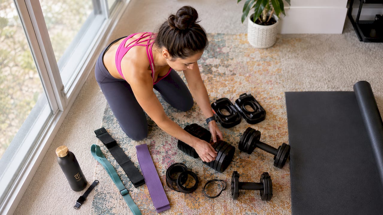 Woman setting up home workout equipment