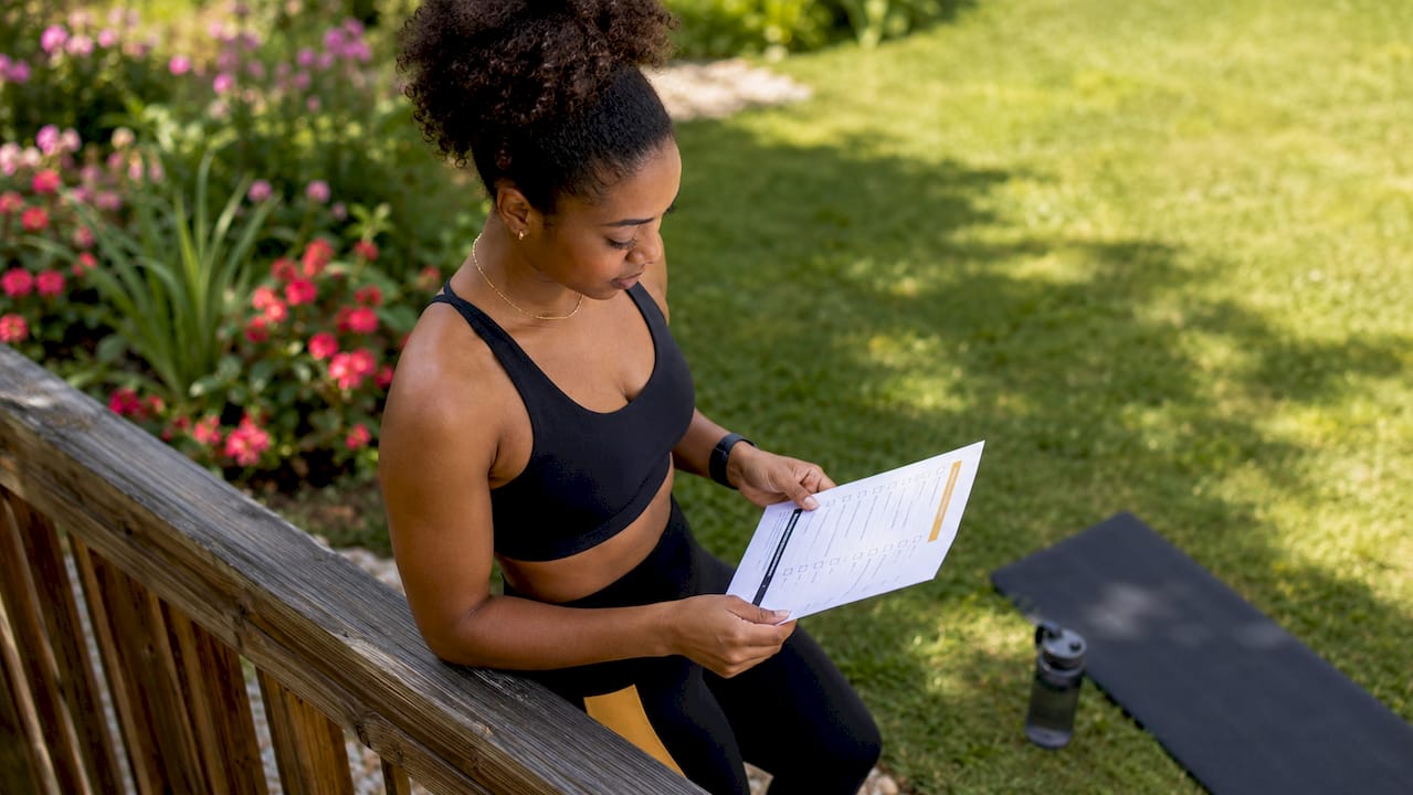Woman reviewing personal trainer checklist in gym