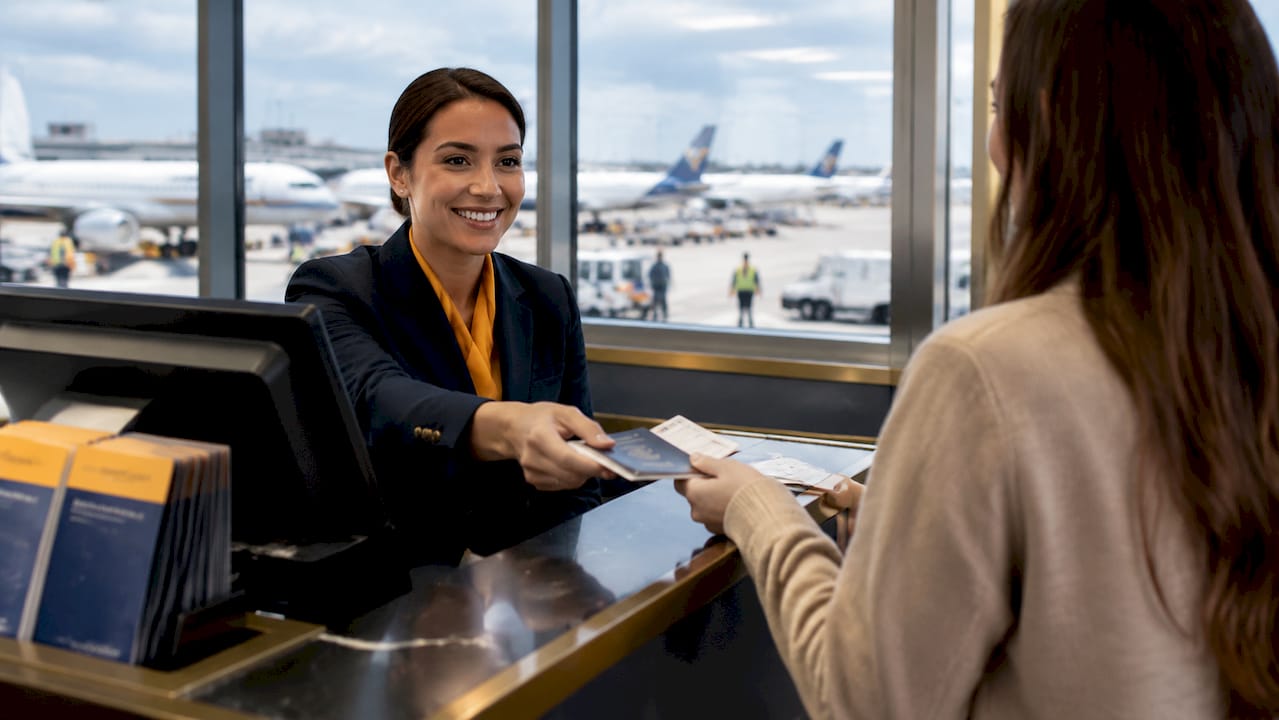 Airline agent verifying passenger's passport and ticket