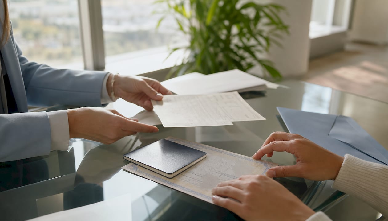 Hands sorting original identity documents on desk