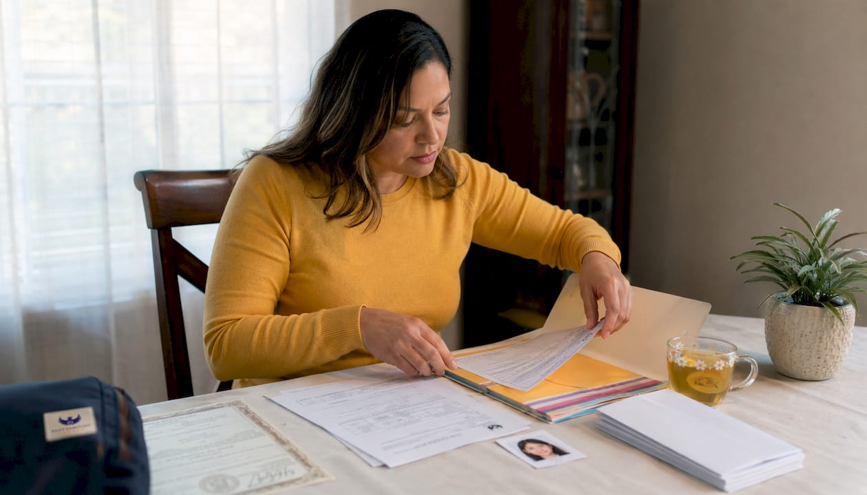Parent organizing child passport documents on table