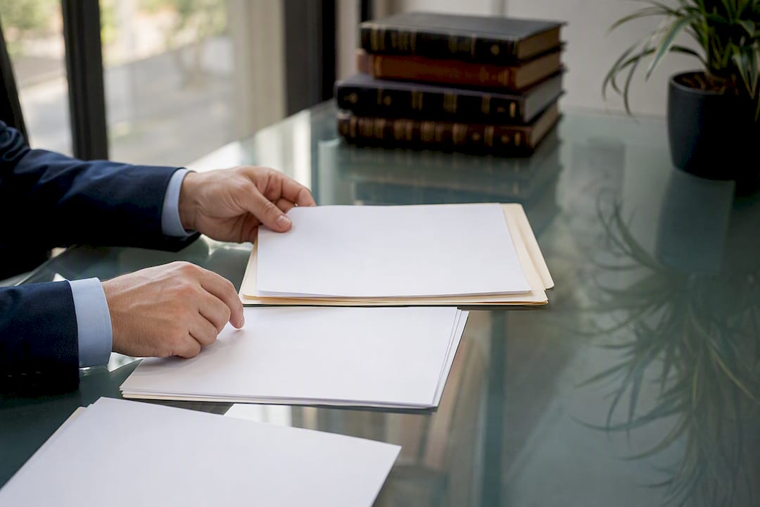 Hands arranging legal estate documents
