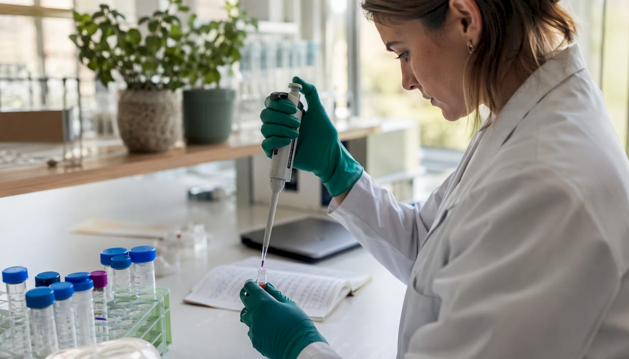 Researcher's hands pipetting in biochemistry lab