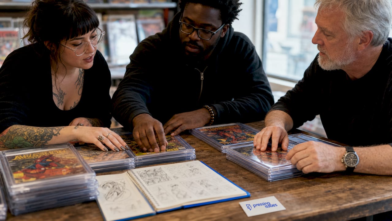 Hands sorting graded comics on desk