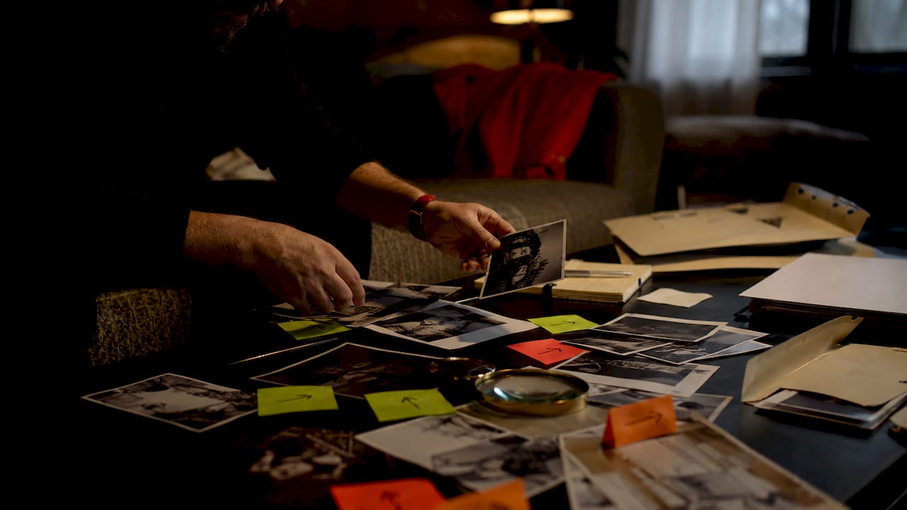 Hands arranging and analyzing mystery clues on table