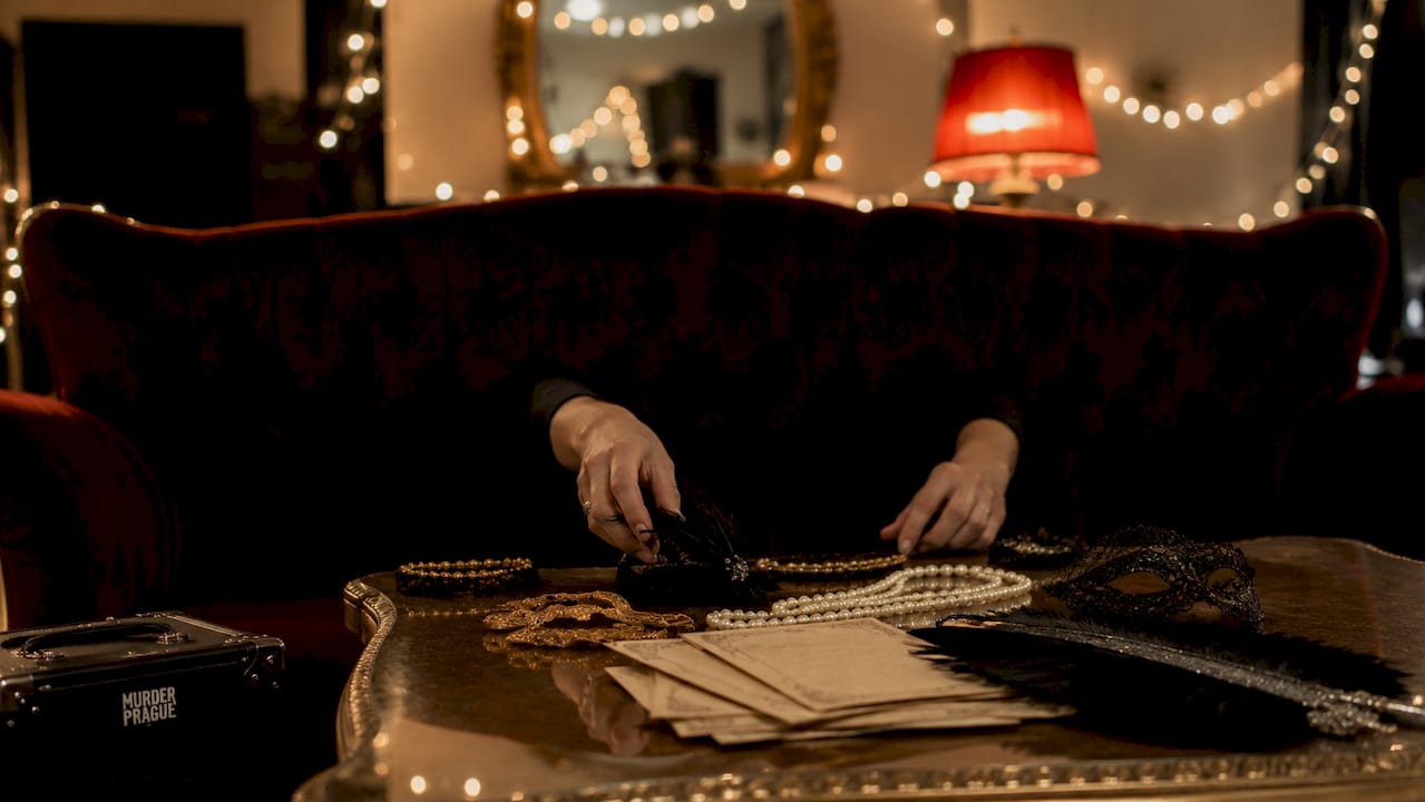 Hands arranging 1920s mystery party decor items