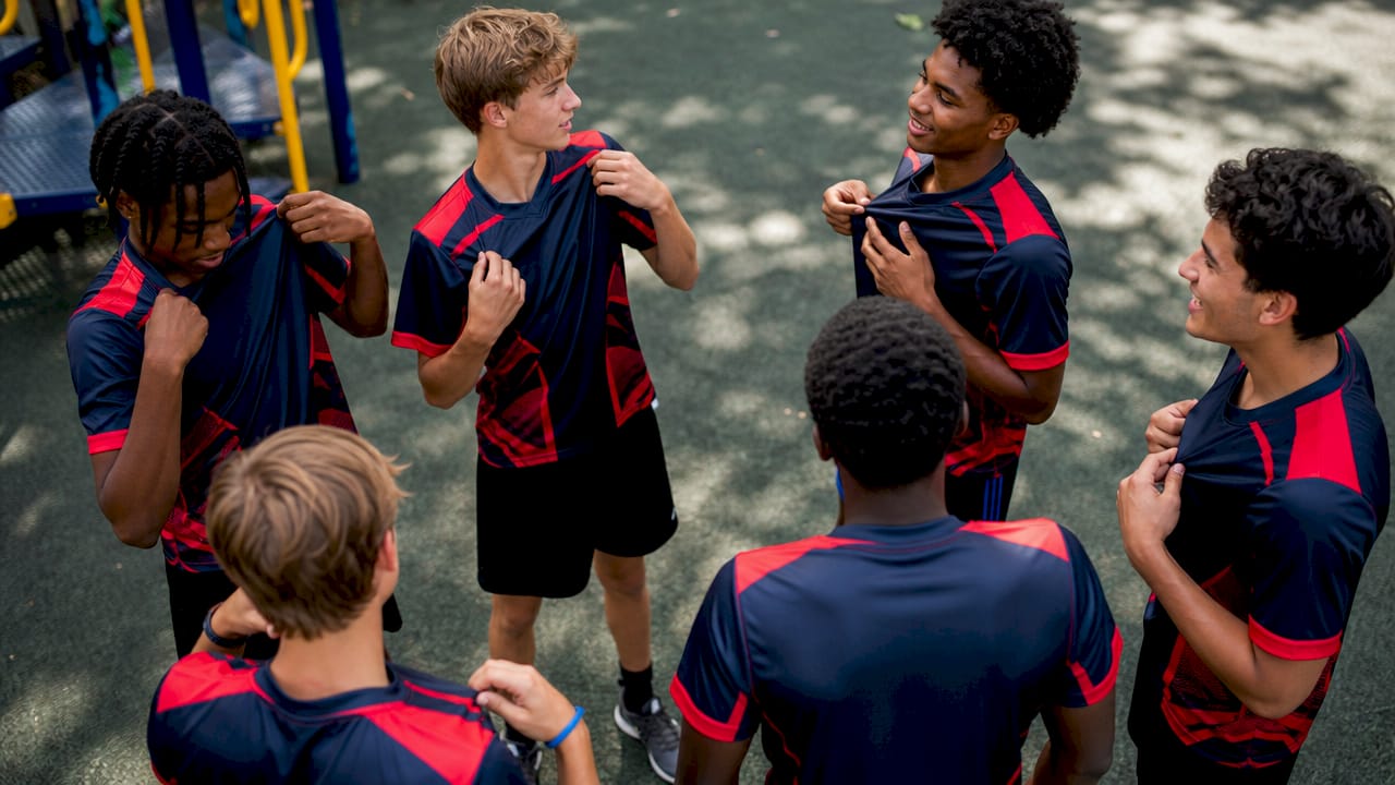 Athletes putting on matching team jerseys outside