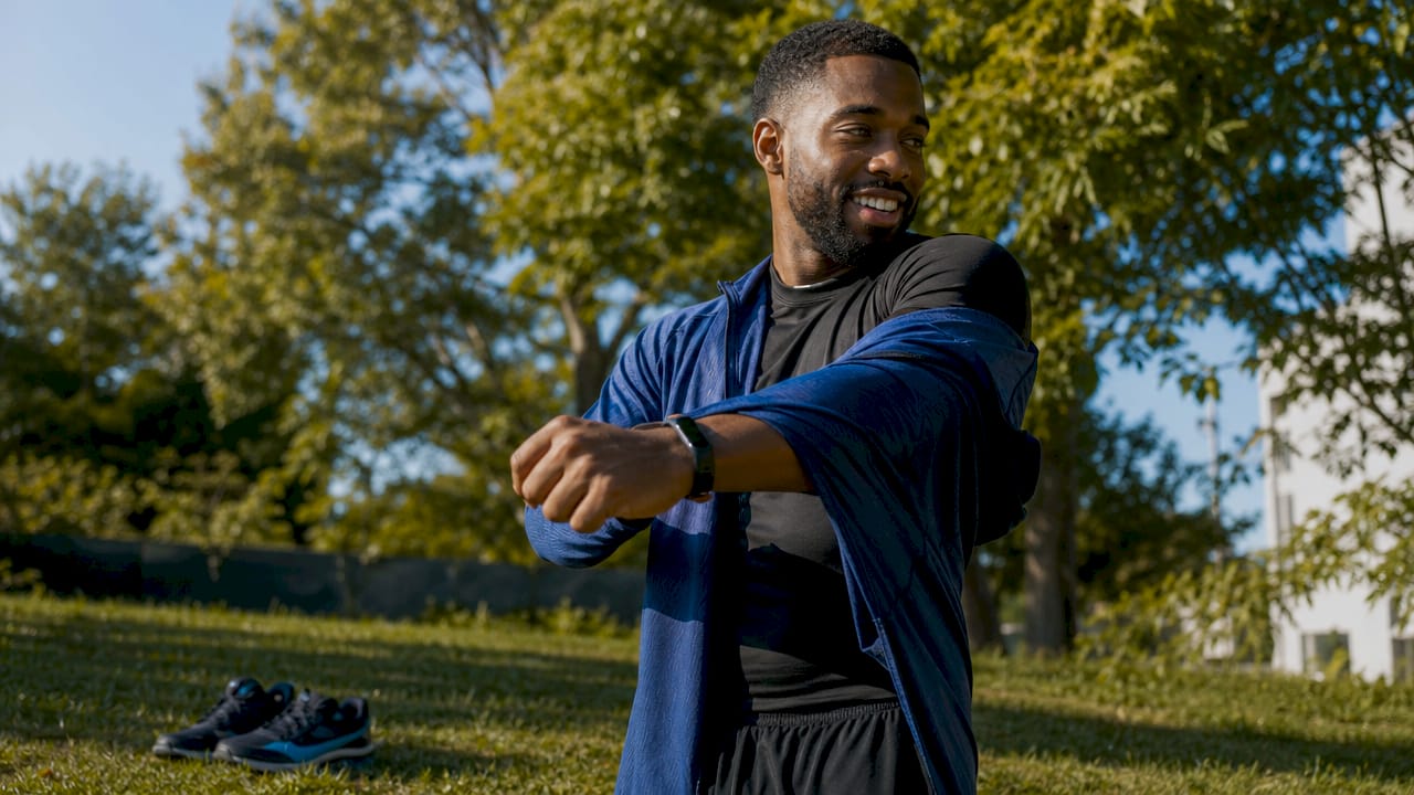 Athlete layering warm-up apparel in locker room