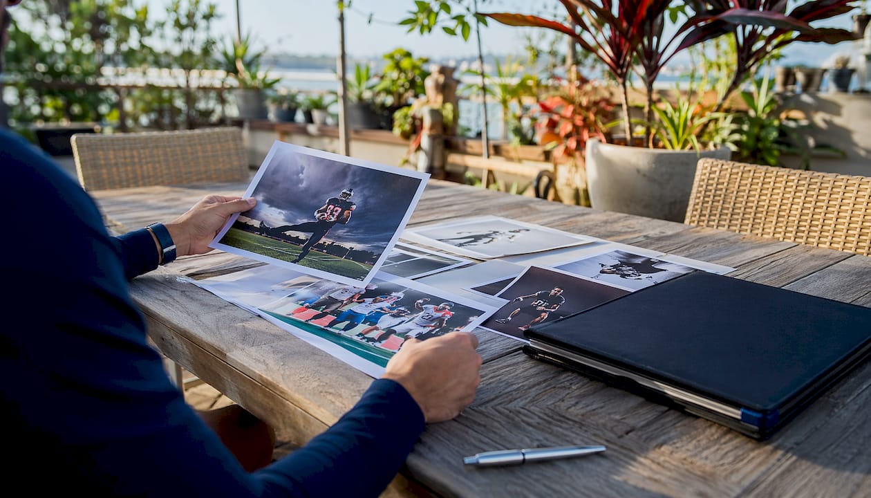 Hands arranging sports portfolio documents on desk