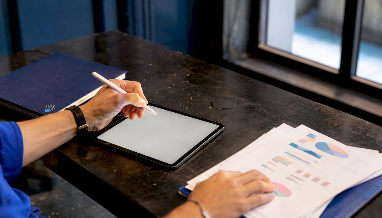 Hands using tablet and paper charts