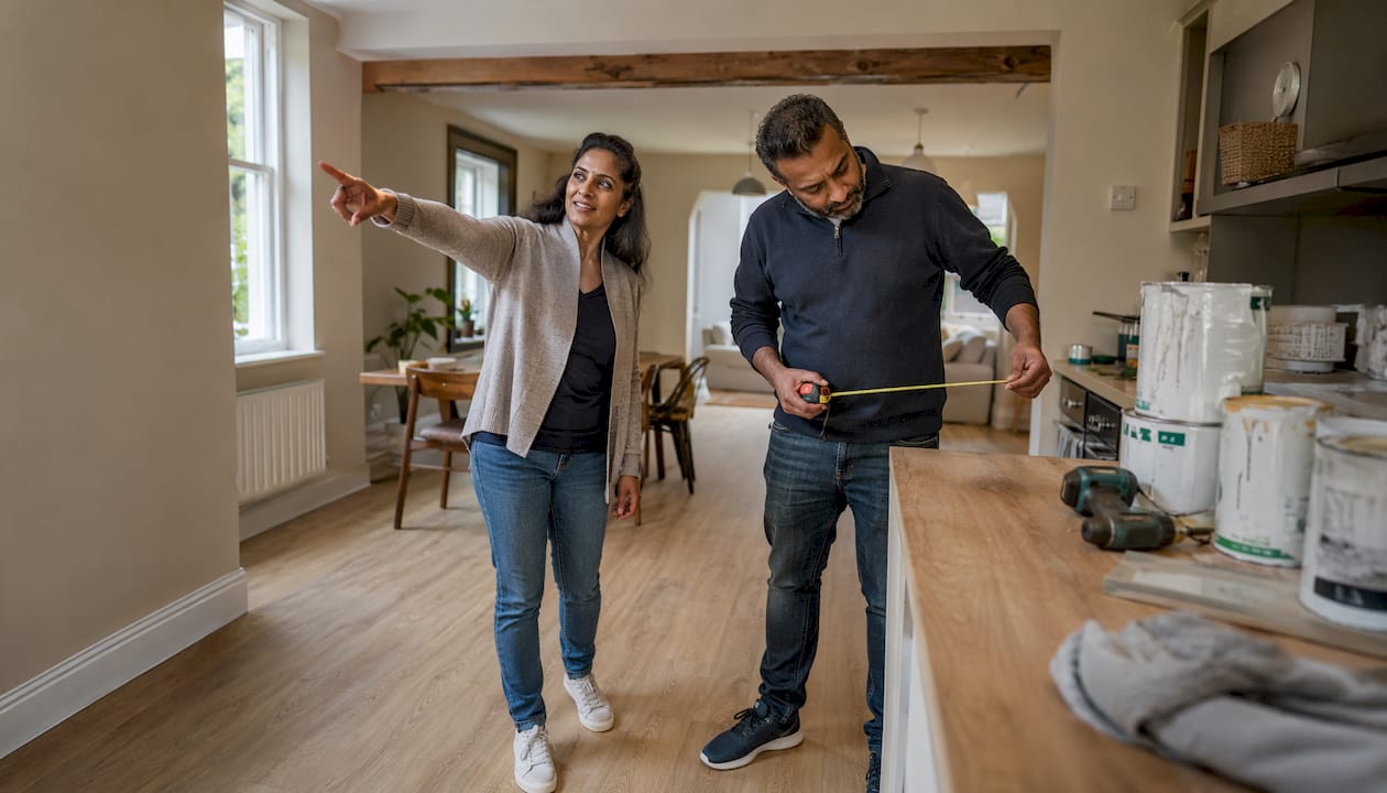 Couple examining kitchen knock-through renovation