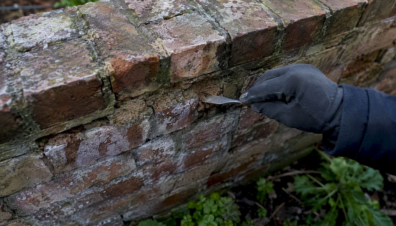 Frost-damaged brick wall with loose mortar