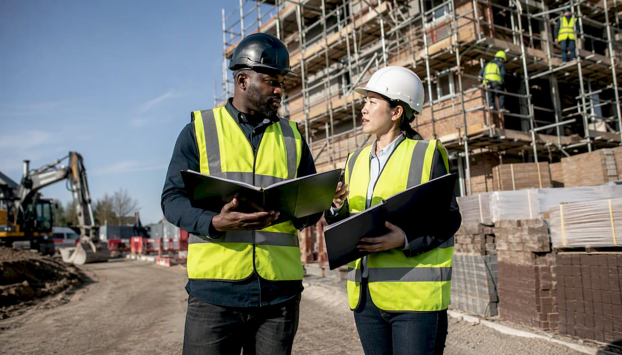 Managers discussing contracts at site trailer