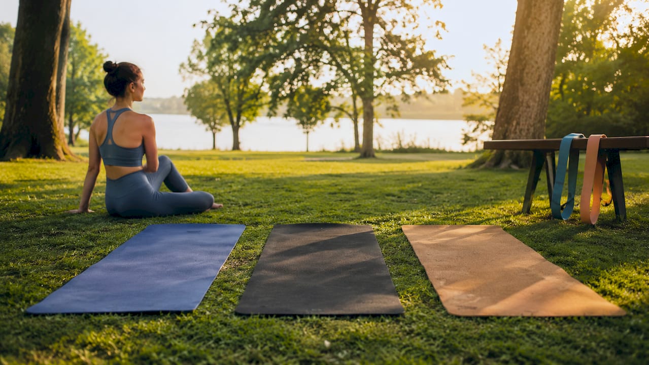 Three yoga mats of PVC, rubber, and cork materials