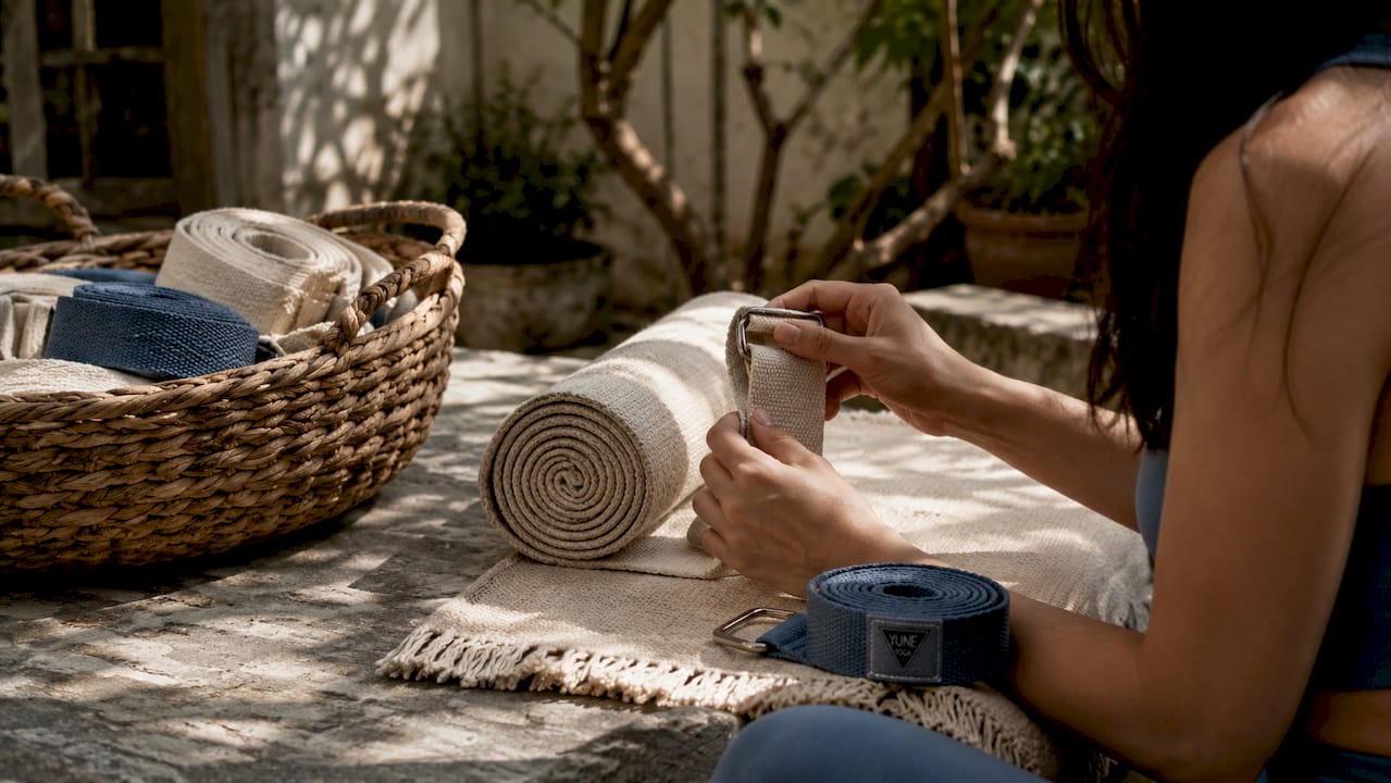 Hands handling organic cotton yoga strap and hemp towel