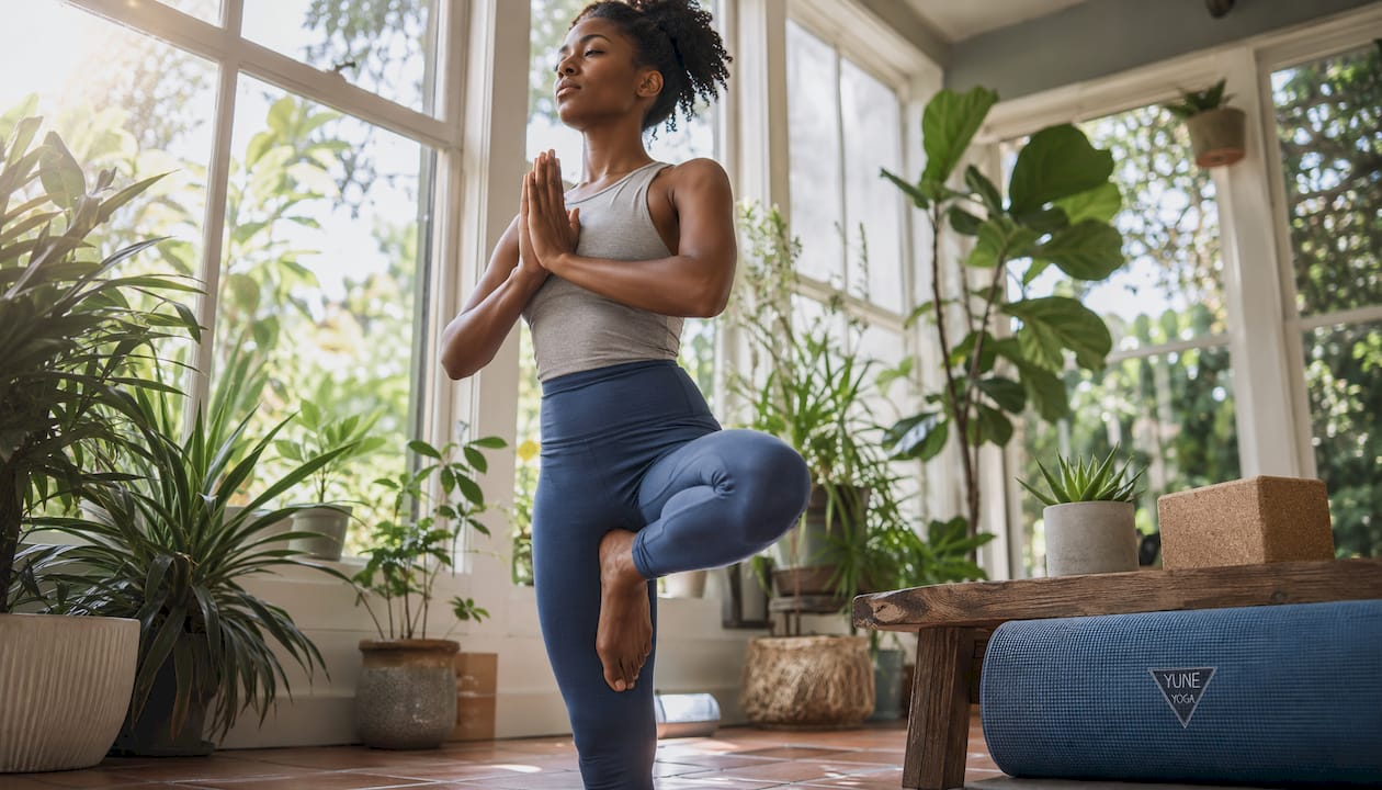 Female athlete holding tree yoga pose in studio