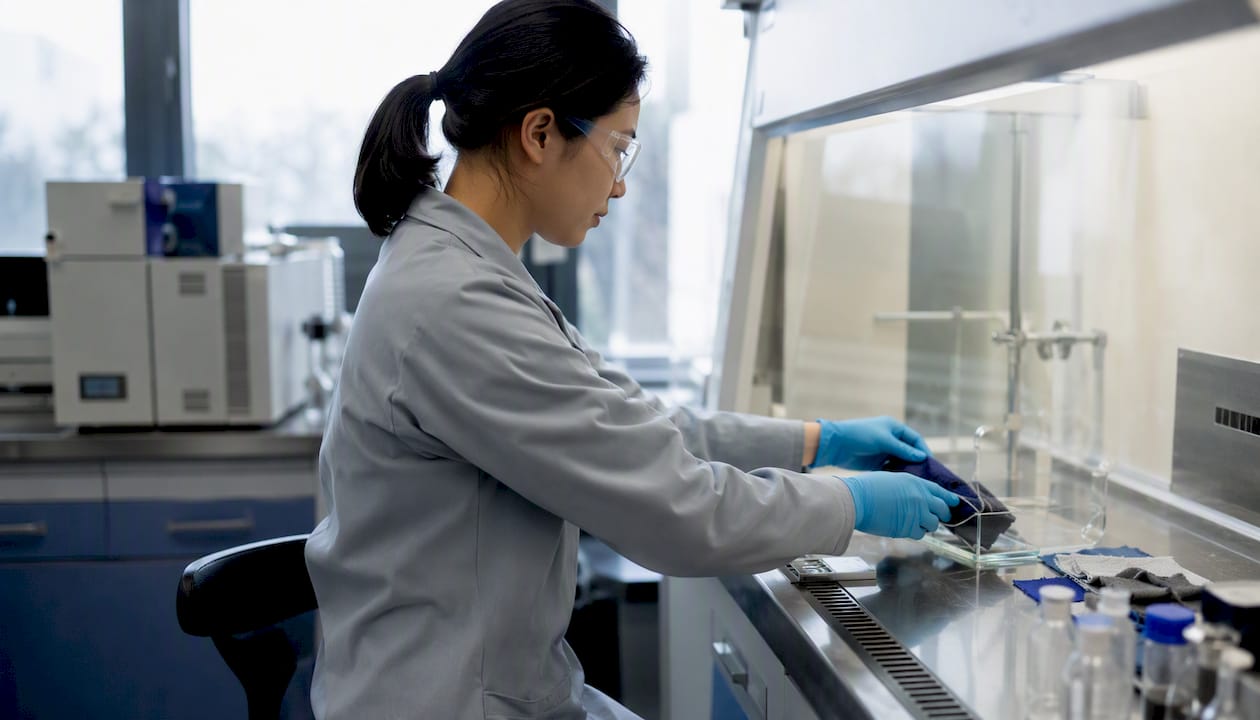 Hands testing textile samples in lab