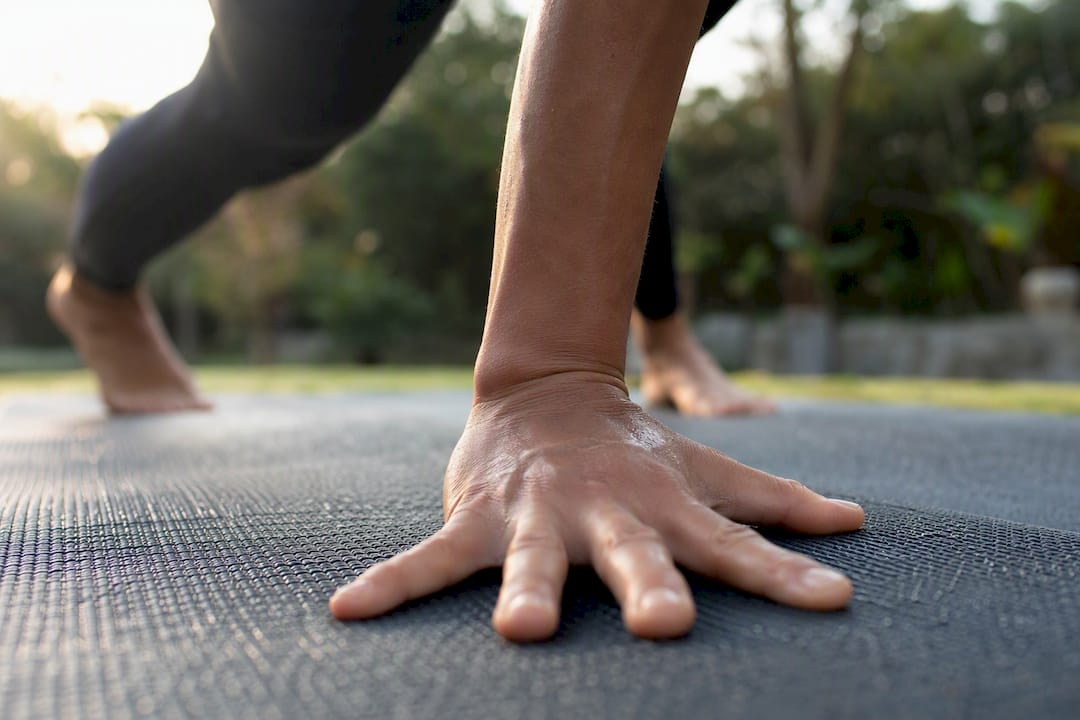 Hand gripping textured yoga mat surface