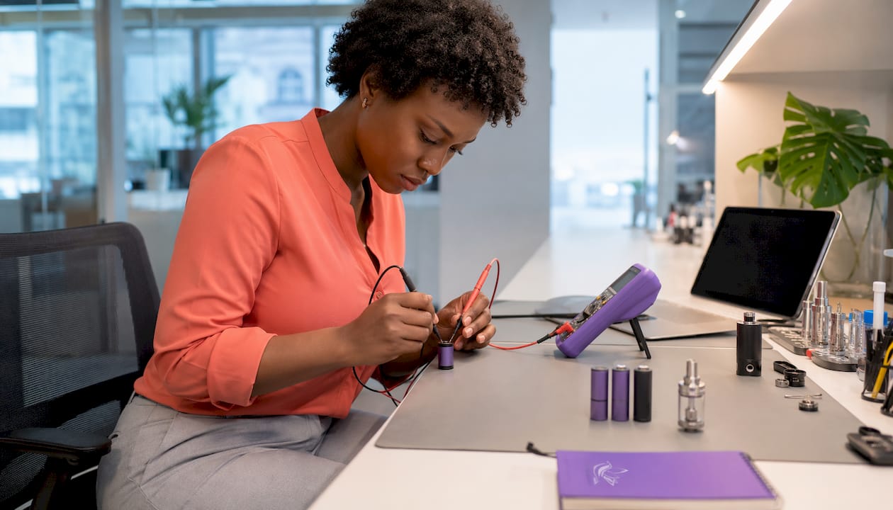 Woman testing voltage of 510 battery with multimeter