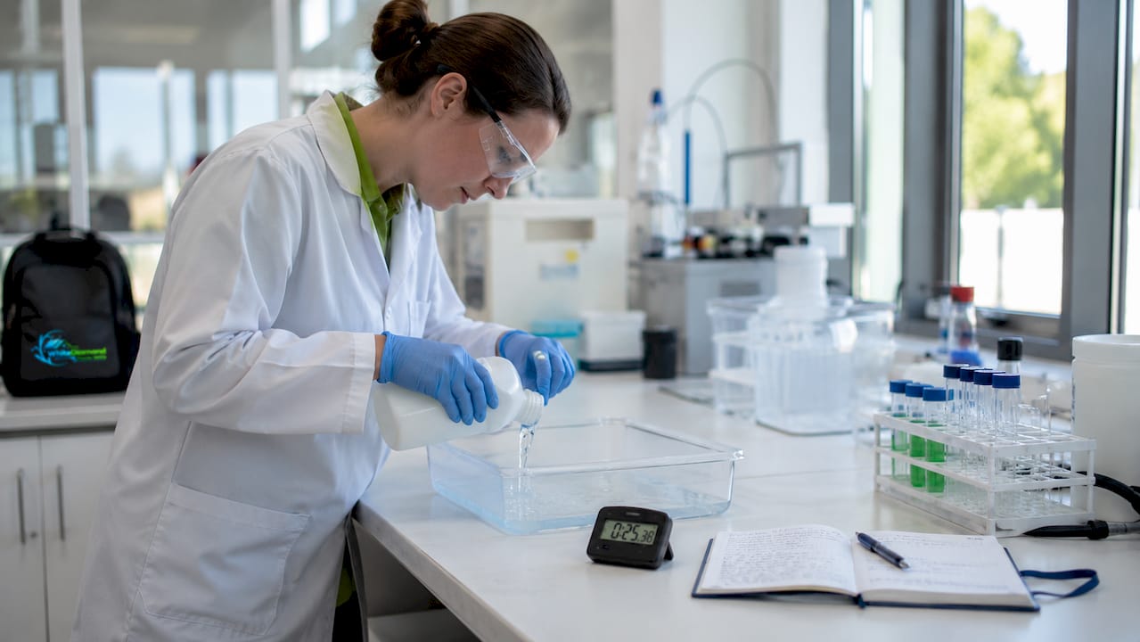 Lab technician preparing disinfectant sample with stopwatch