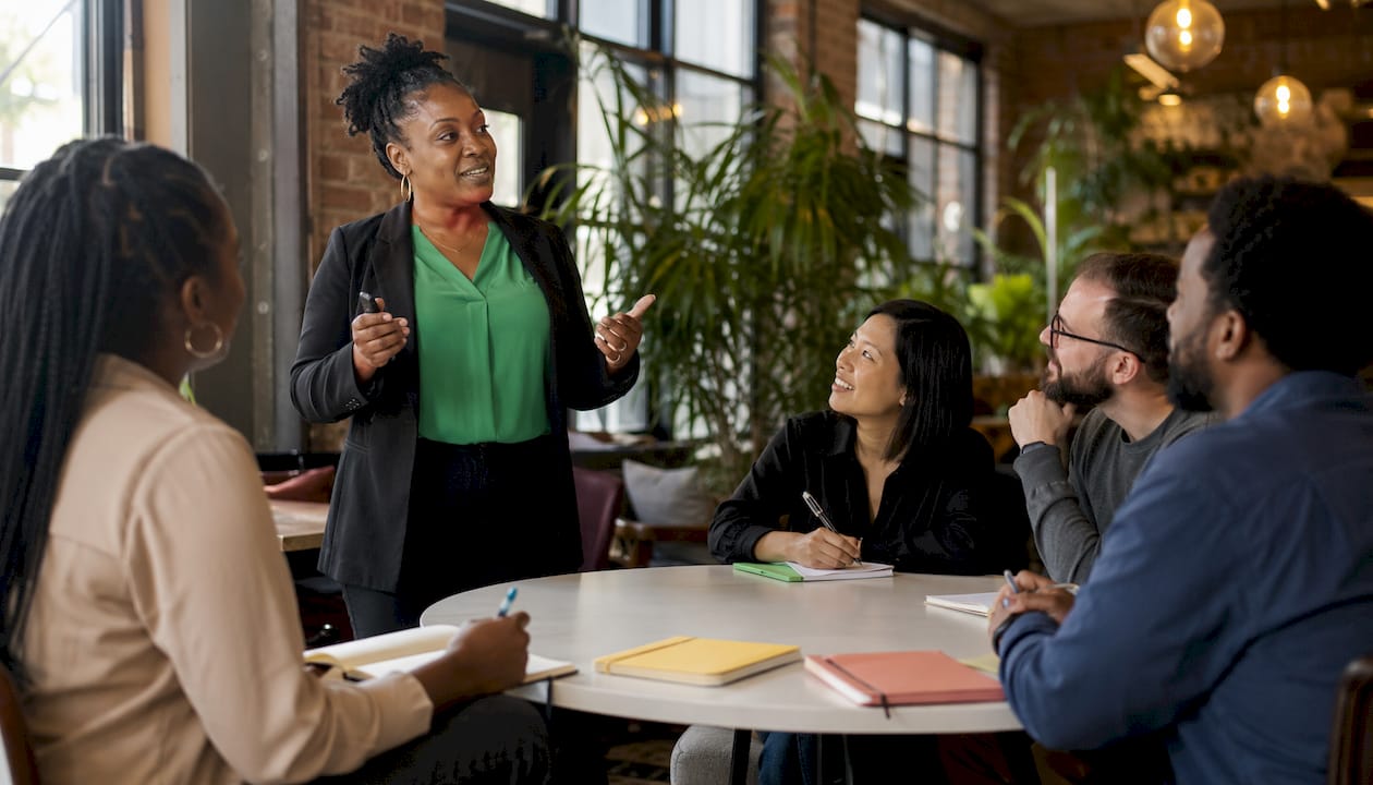 Presenter sharing brand mission with employees in meeting