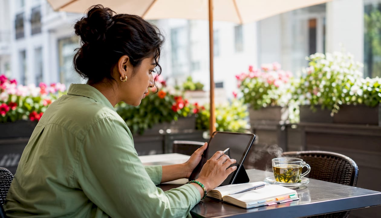 Hands segmenting retargeting audience data on tablet at café