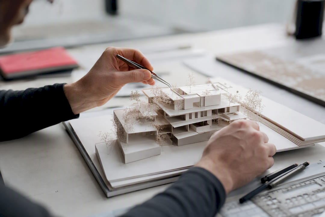 Hands fixing anchor point on architectural model