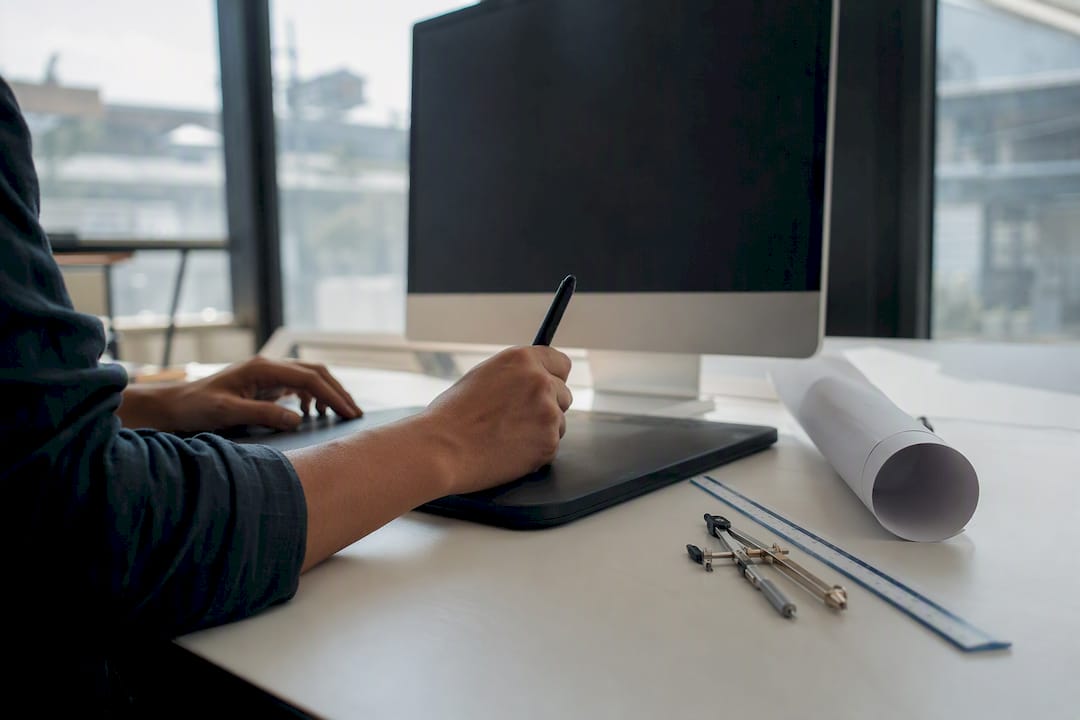Hands operating mouse on architect workspace