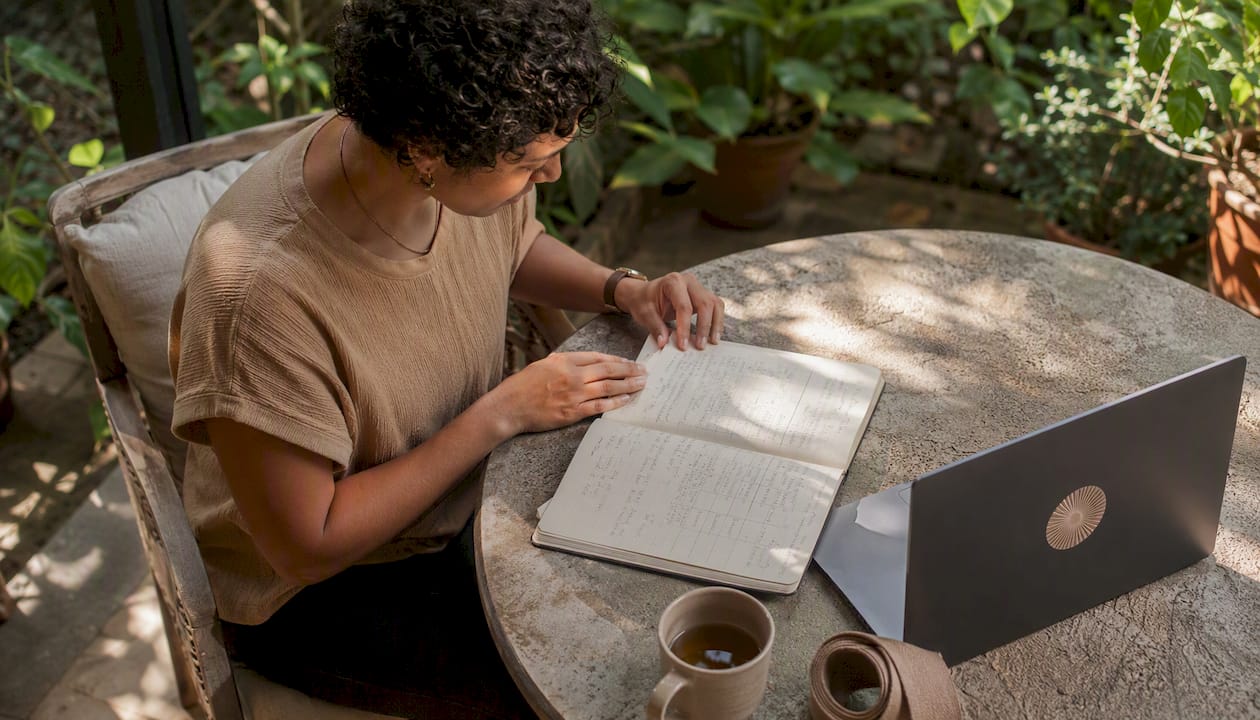 Person reviewing yoga class notes at home table
