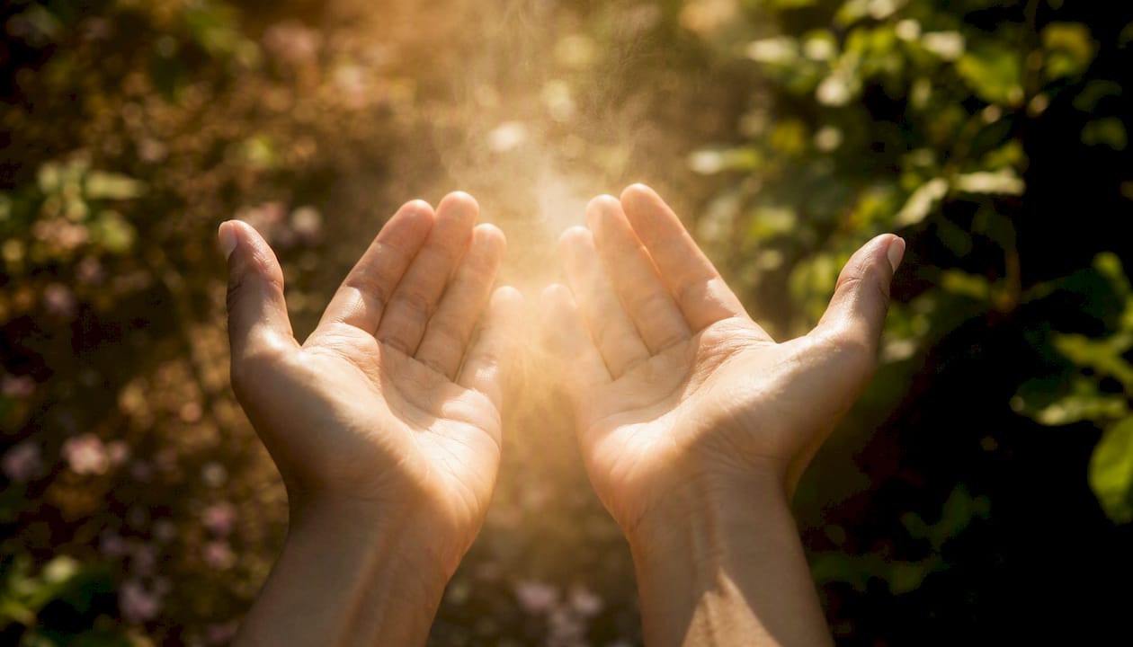 Hands releasing soft energy light in warm room