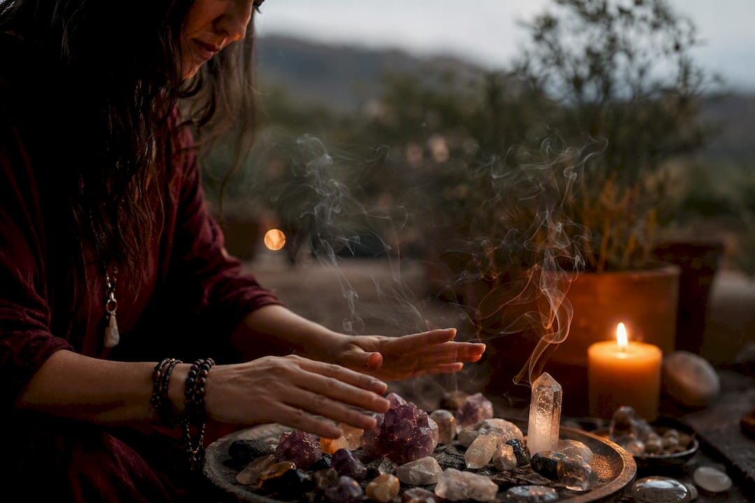 Hands performing energy healing with crystals