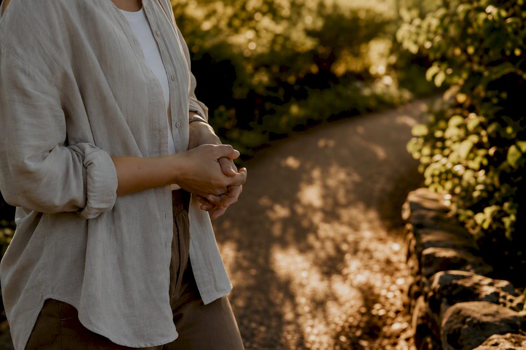 Person’s hands relaxed walking in sunlit garden