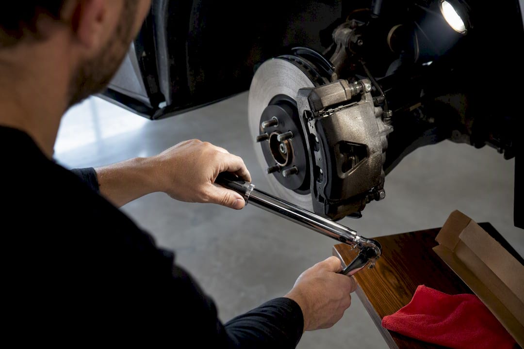 Mechanic using torque wrench during brake installation