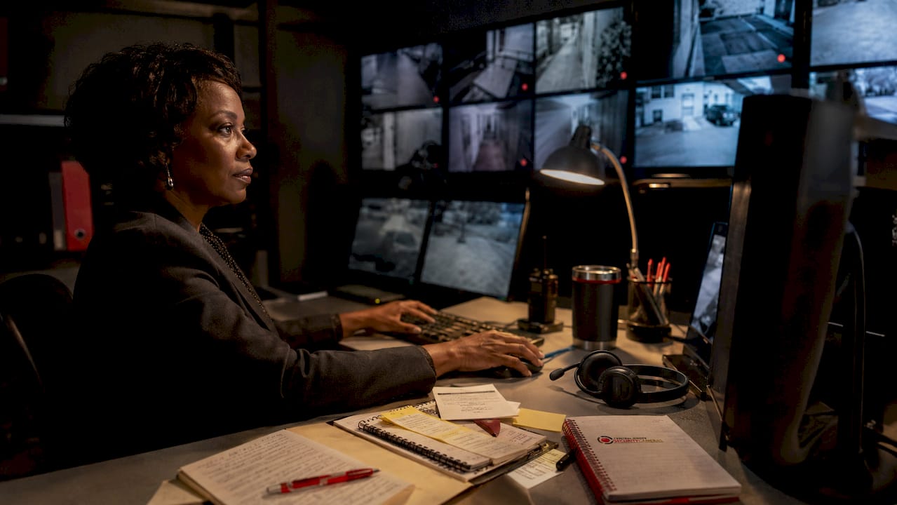 Security officer monitoring CCTV footage at control desk