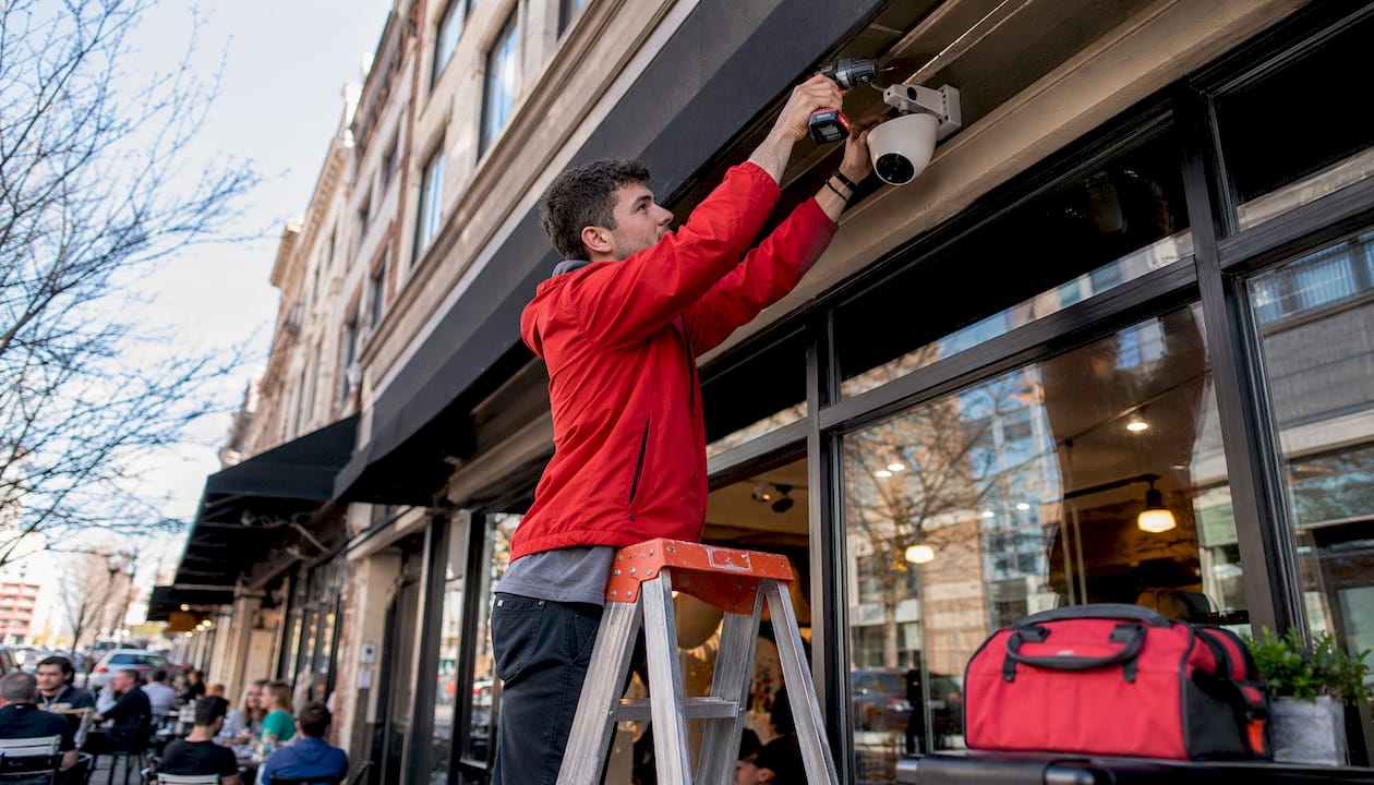 Technician installing security camera outdoors