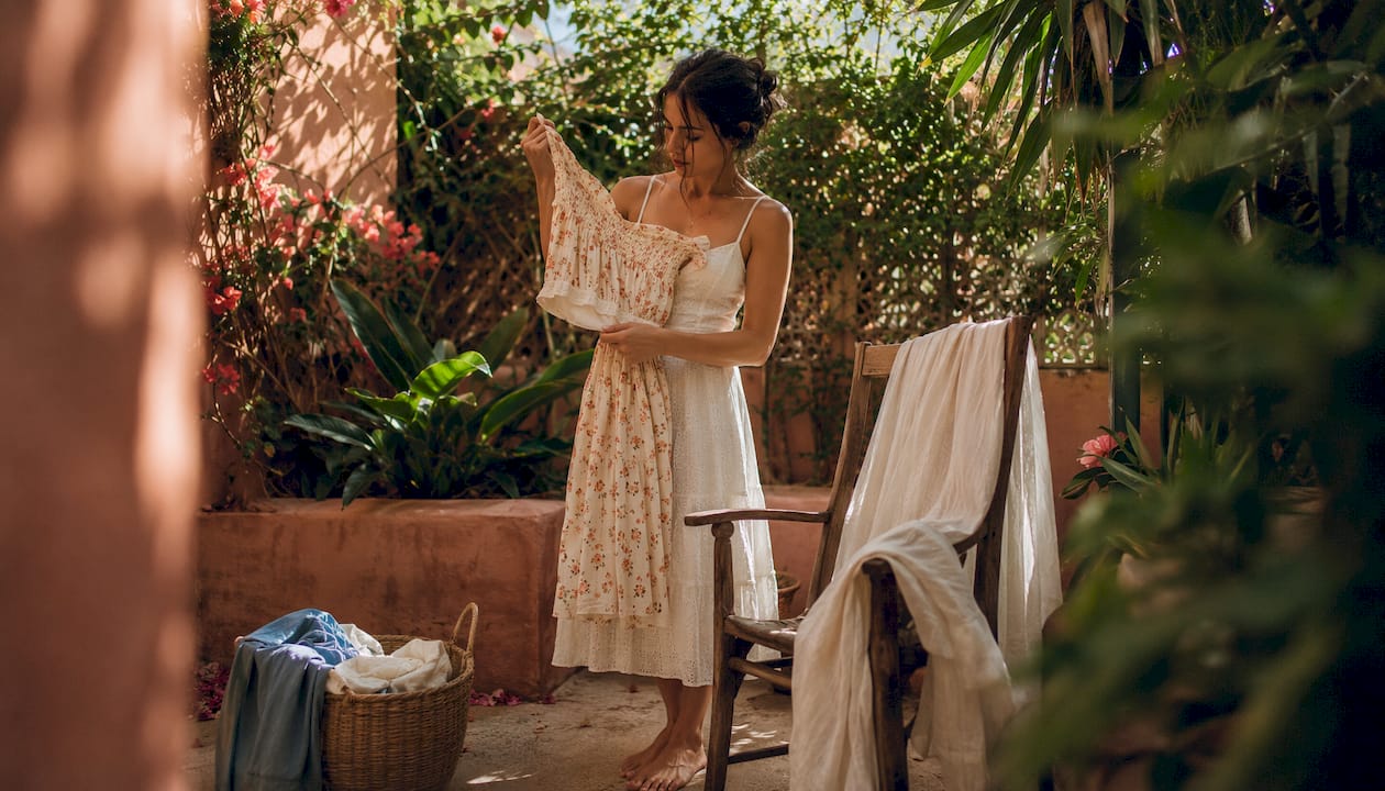 Woman with cotton matching set examining outfit in bedroom