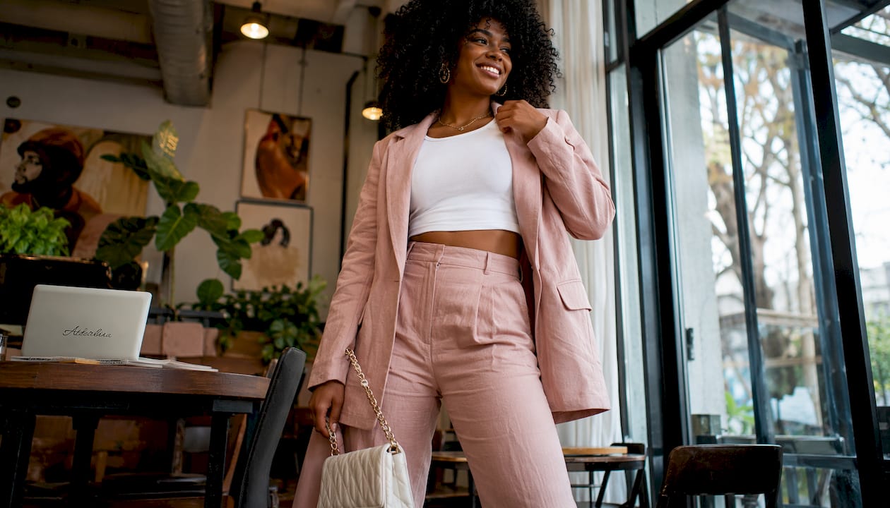 Woman in crop top and blazer with trousers indoors