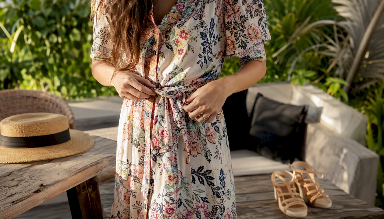 Hands tying cotton floral midi dress waist belt