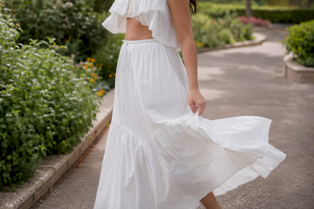 Woman adjusting loose cotton skirt in breeze