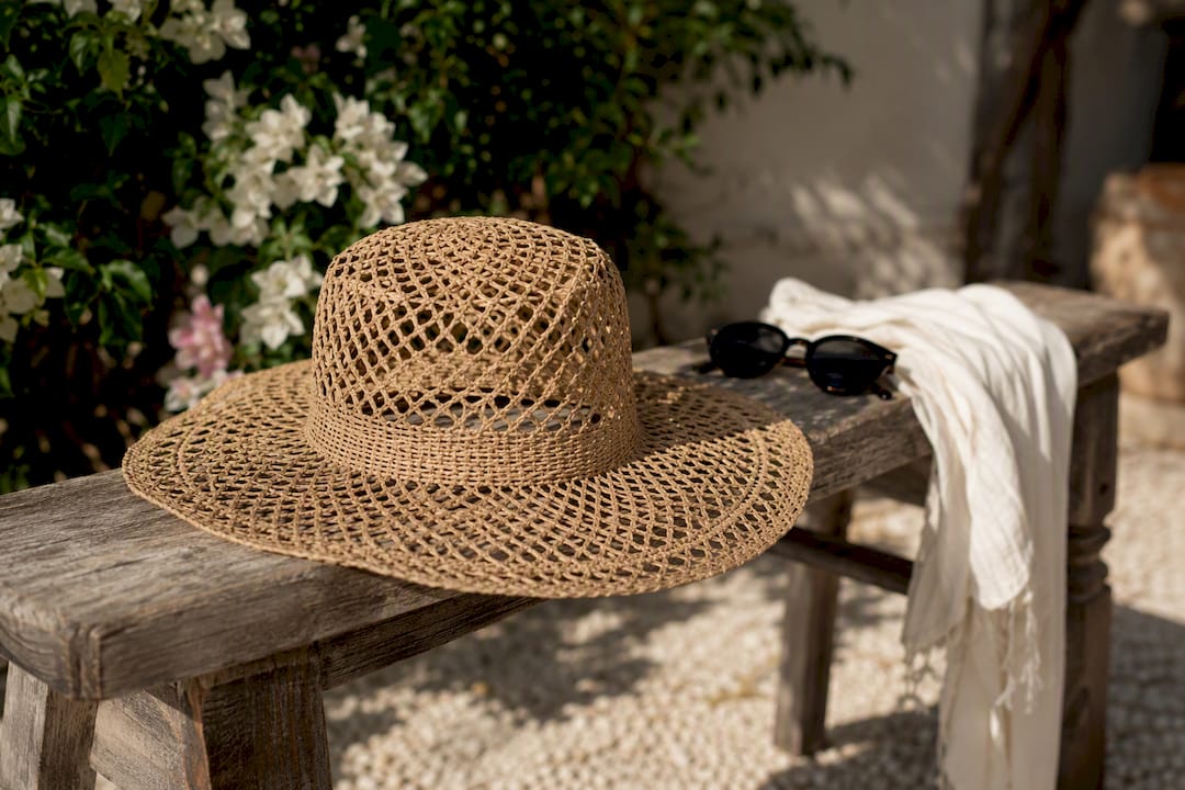 Wide-brim straw hat on wooden table outdoors