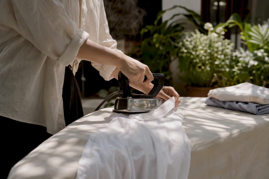 Hands ironing collar of cotton shirt