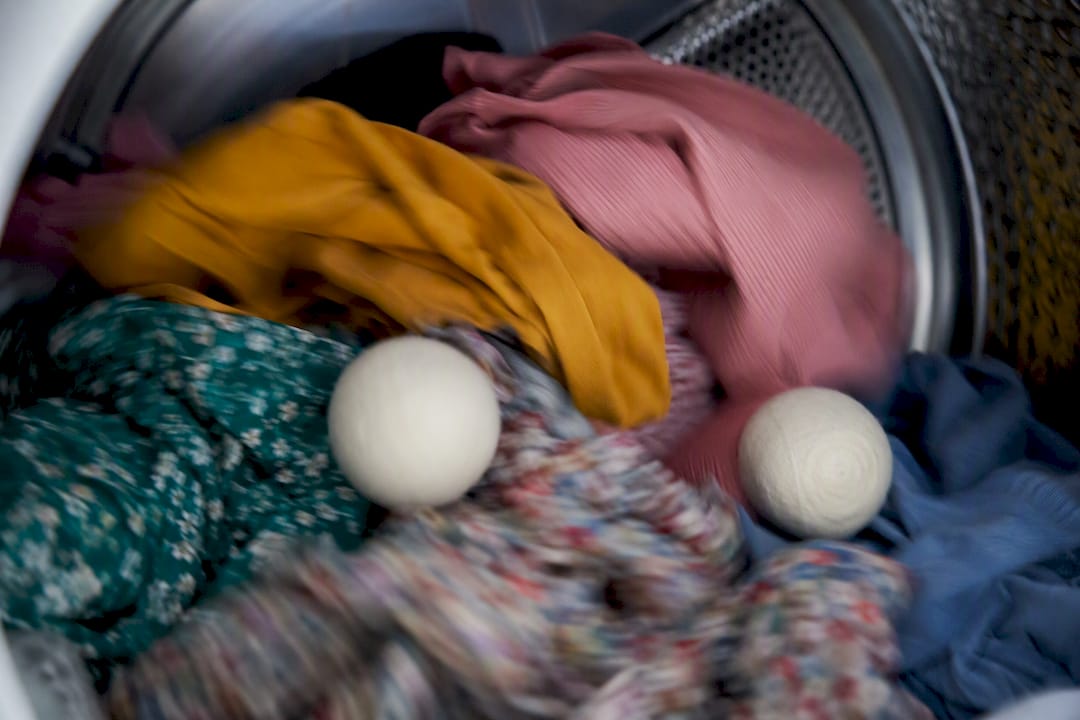 Dryer balls tumbling with cotton clothes inside dryer