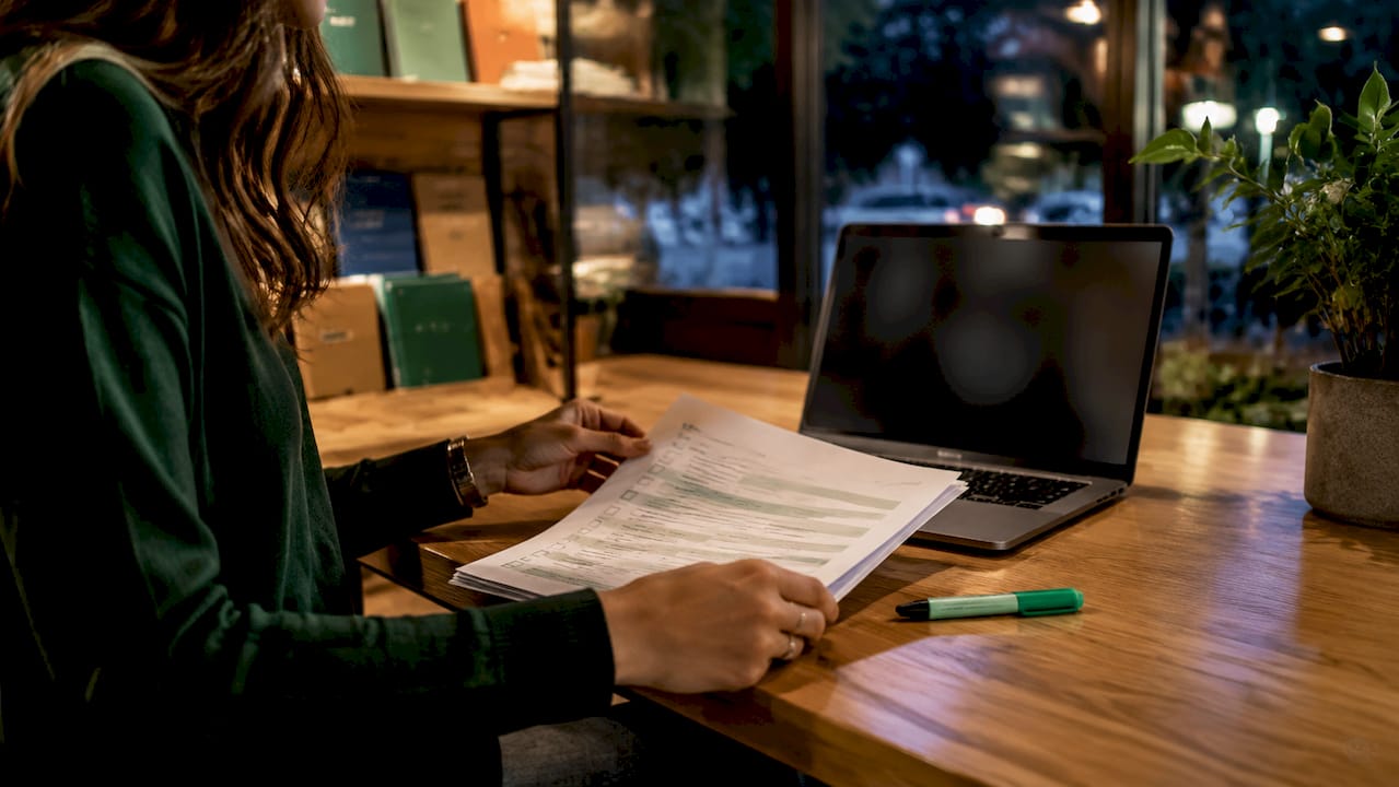 Hands scrolling CRM spreadsheet and checking checklist