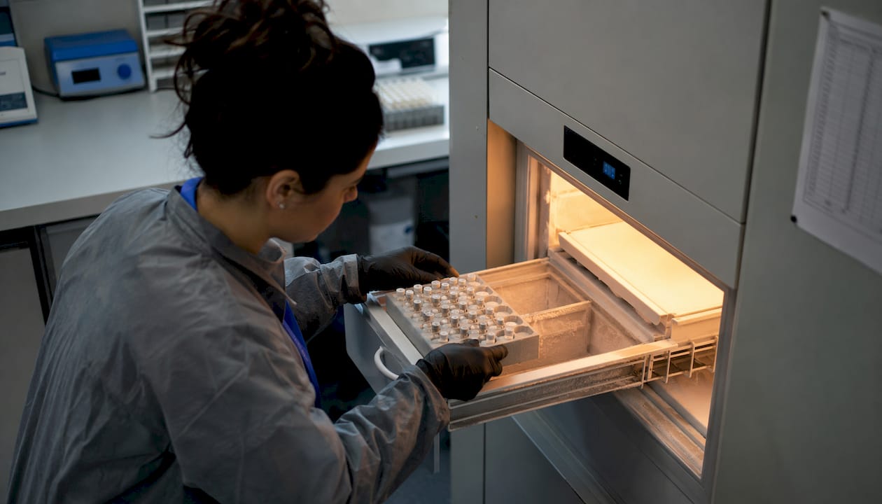 Scientist storing peptide aliquots in ultra-low freezer