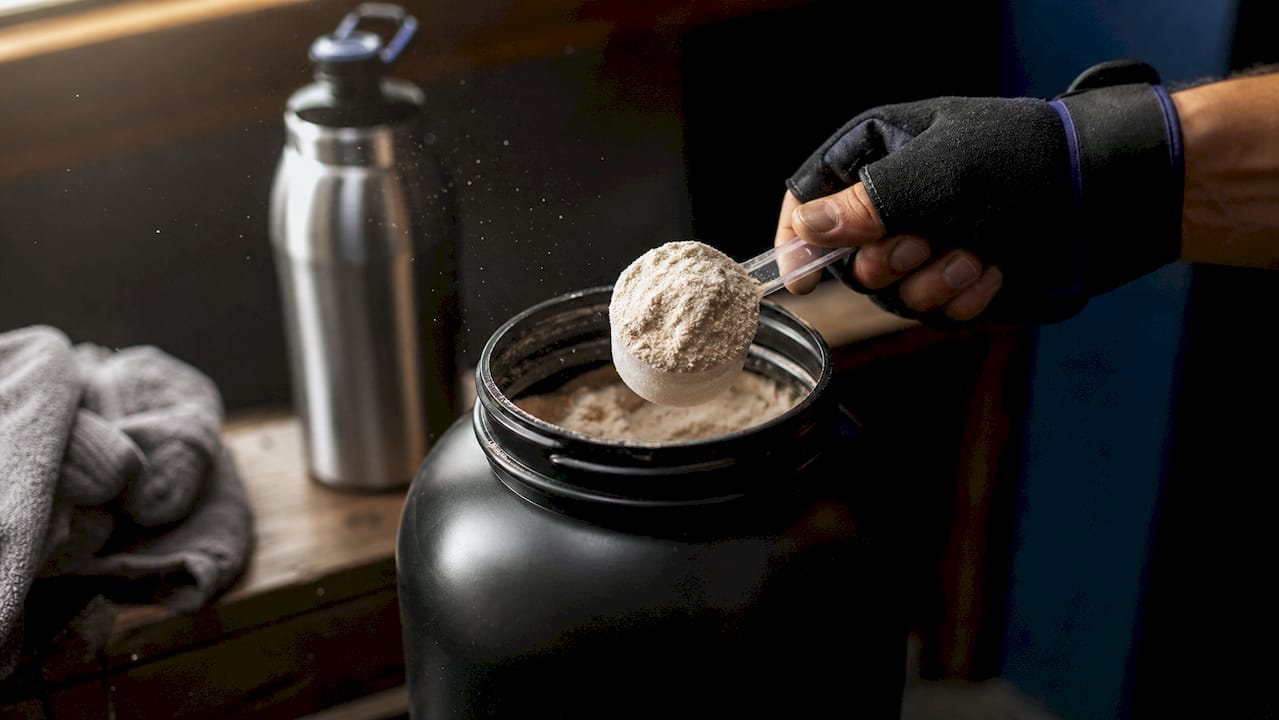 Close-up of whey protein isolate powder scoop in gym