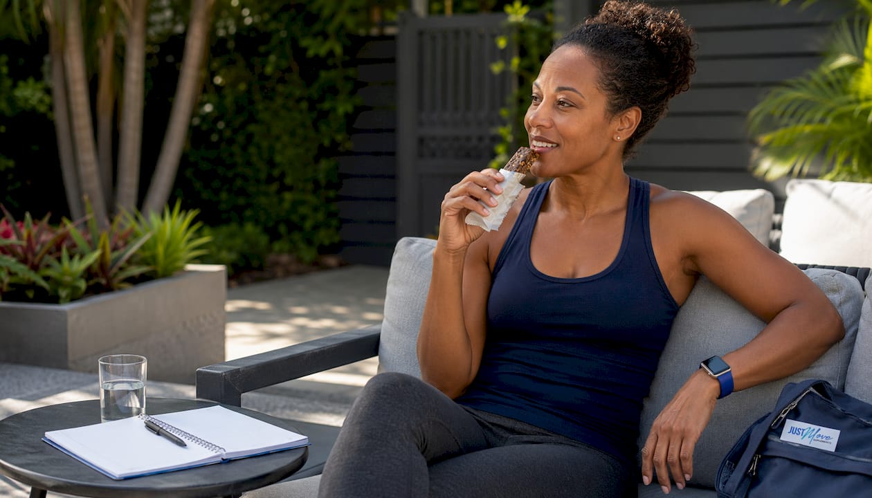 Black woman eating solid meal replacement bar