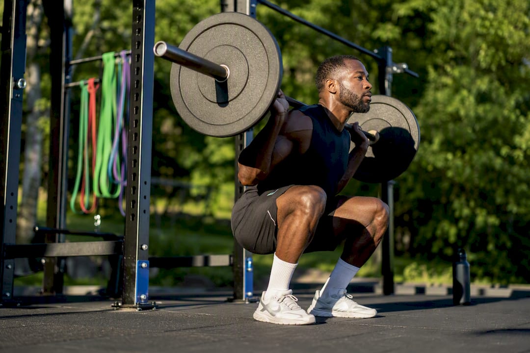 Black man performing eccentric back squat phase